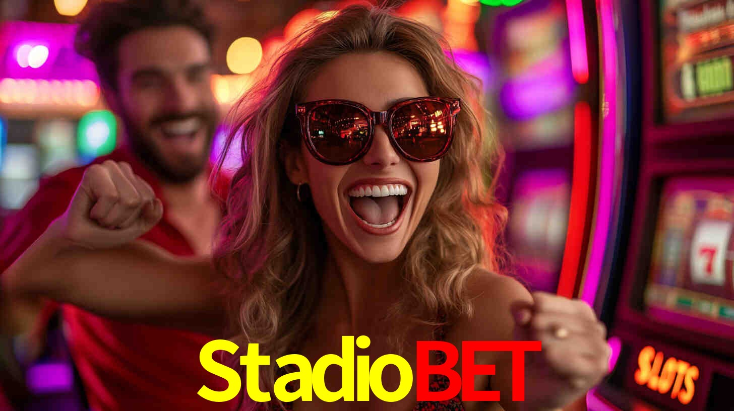 Una escena digital vívida inspirada en casino con Stadiobet mostrado prominentemente, luces brillantes, fichas, cartas y acentos dorados.